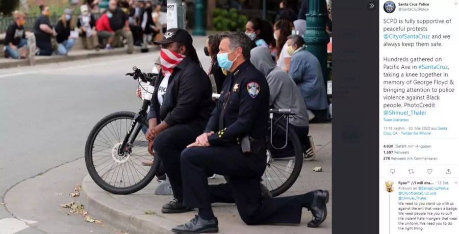 An verschiedenen Orten in den USA haben sich Polizeibeamte mit den Demonstranten solidarisiert. Dieses Foto zeigt einen Beamten in Santa Cruz, der mit Demonstranten niederkniet, um ein Zeichen gegen Polizeigewalt zu setzen.