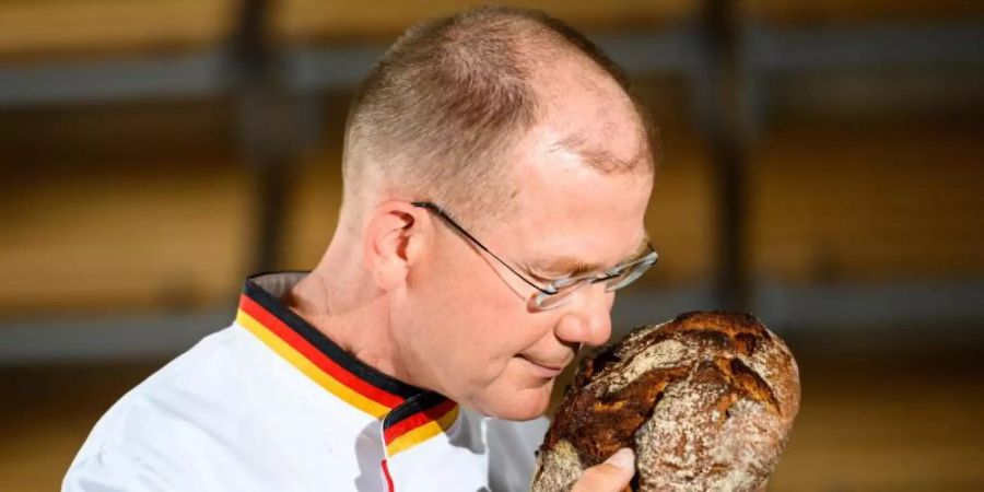 Stefan Keller, Bäckermeister und Brotsommelier, riecht an einem frischen Brot. Foto: Andreas Arnold/dpa