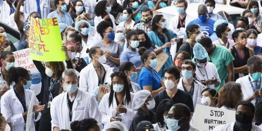 Medizinische Angestellte des Krankenhauses «Kings County Hospital» in Brooklyn zeigen bei einer Kundgebung ihre Solidarität mit der Bewegung «Black Lives Matter». Foto: Mark Lennihan/AP/dpa