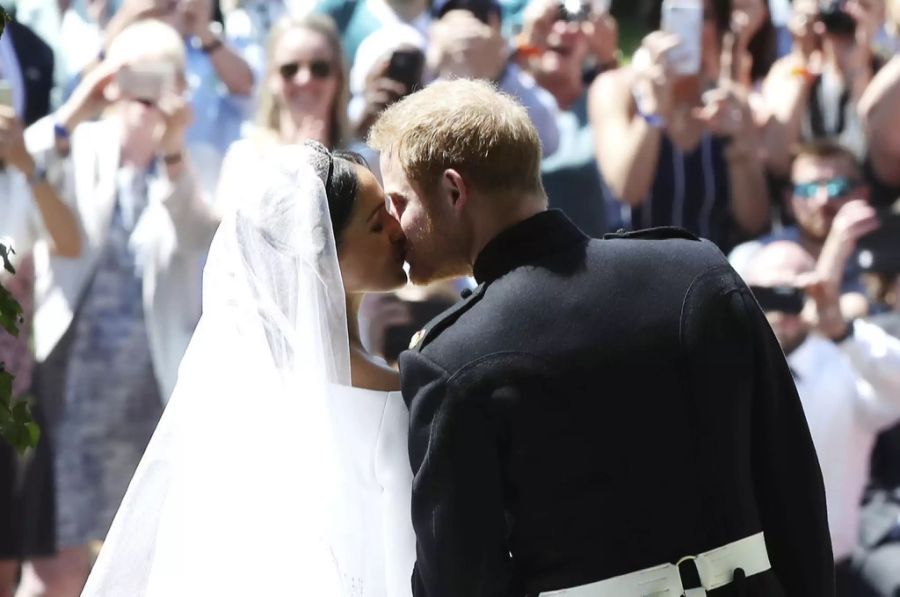 Hier küssen sich Meghan Markle und Prinz Harry an ihrer Hochzeit vor den Schaulustigen.