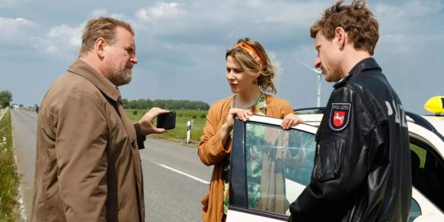 Kommissar Brockhorst (Felix Vörtler, l) und Henk Cassens (Maxim Mehmet, r) stoppen Susanne Bock (Katrin Röver) auf der Strasse. Foto: Kai Schulz Fotodesign/ZDF/dpa