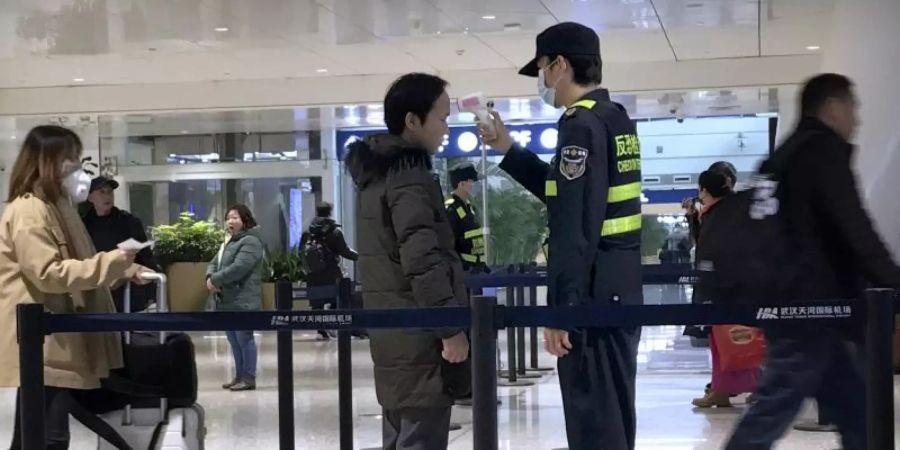 Temperaturmessung am Flughafen Wuhan Tianhe International Airport bei den Passagieren. Die Verunsicherung durch den Coronavirus ist gross. Foto: Emily Wang/AP/dpa