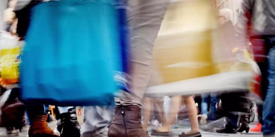 Passanten mit Einkaufstüten. Die deutsche Wirtschaft ist im vergangenen Jahr etwas schwächer gewachsen als zunächst berechnet. Foto: Henning Kaiser