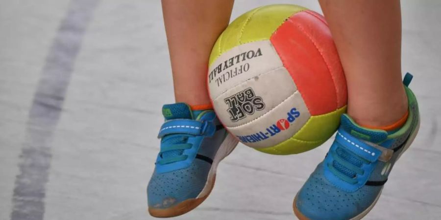 Ein Schulkind hüpft mit einem Ball zwischen den Beinen. Foto: Patrick Pleul/Archiv