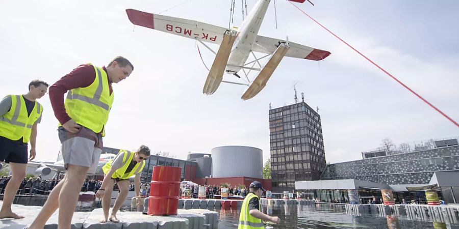 Das Wasserflugzeug Cessna 185 wird im Verkehrshaus der Schweiz in Luzern in einen Pool gehievt, dies anlässlich der Eröffnung des zweiten Teils der Ausstellung «Die Schweiz fliegt!»