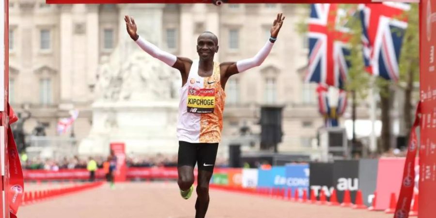 Der Kenianer Eliud Kipchoge überquert in London als Erster die Ziellinie. Foto: Paul Harding/PA Wire/dpa