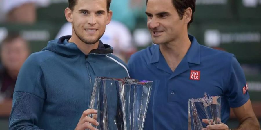 Finalsieger Dominic Thiem (l) steht mit seiner Trophäe neben dem unterlegenem Roger Federer. Foto: Mark J. Terrill/AP