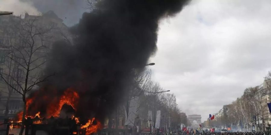 Ein Kiosk steht auf den Champs-Elysees in Flammen. Foto: Christophe Ena/AP