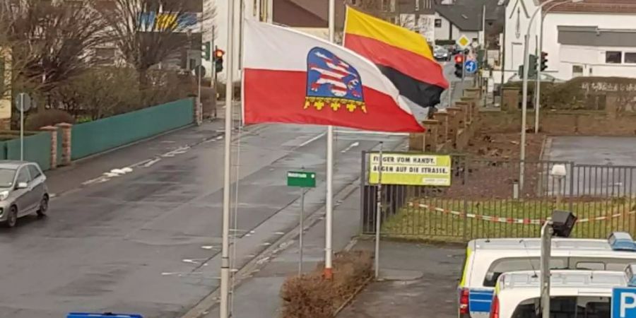 Die Deutschland- und die Hessenfahne sind am 27.01.2019, dem Tag des Gedenkens an die Opfer des Nationalsozialismus, vor einer Polizeiwache im osthessischen Schlüchtern kopfüber gehisst. Foto: Privat