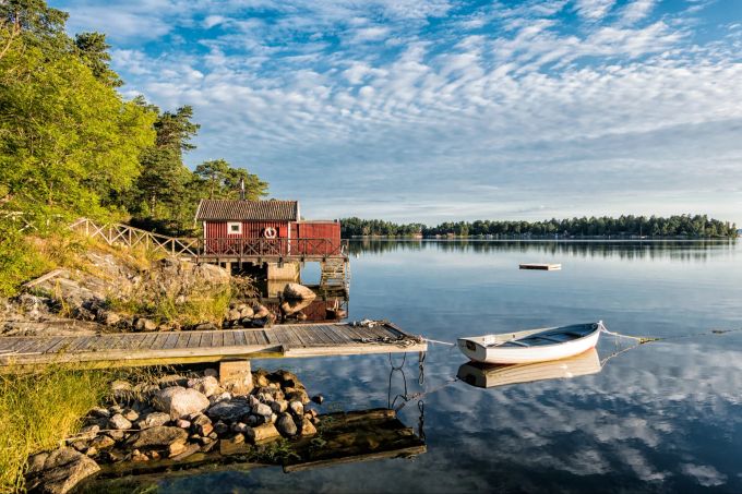 Die Schäreninseln in Schweden sind im Frühling und Sommer ein Traum. Rote Fischerhütte am See in Schweden.