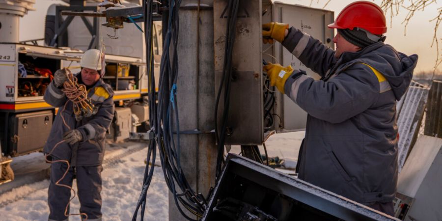 dpatopbilder - Elektriker reparieren einen Strommast, nachdem ein Transformator infolge eines Spannungsstoßes durch russische Luftangriffe auf die Energieinfrastruktur in der Region Ki...