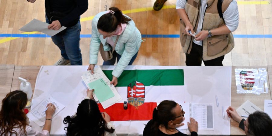 dpatopbilder - Eine Frau nimmt in einem Wahllokal während der ungarischen Parlamentswahlen die Stimmzettel entgegen. Foto: Denes Erdos/AP/dpa
