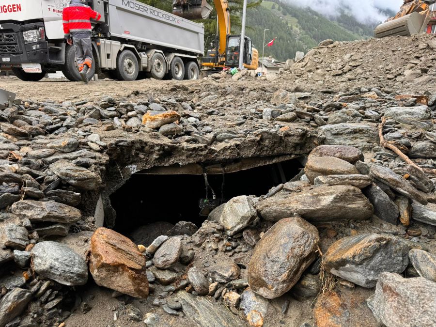 Mit Baggern und schwerem Gerät wird das Geröll auf Lastwagen verladen und abtransportiert.