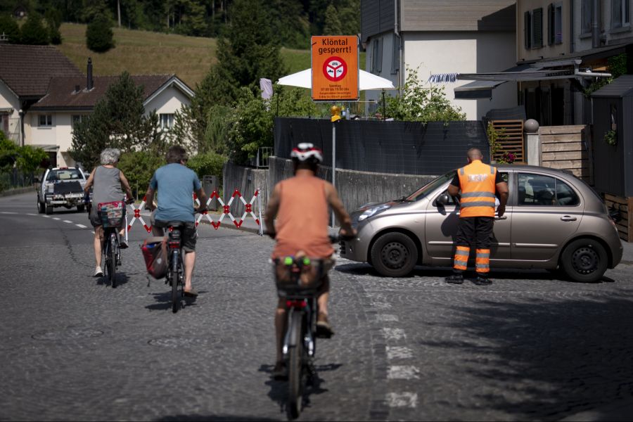 Ein Mitarbeiter eines Sicherheitsdiensts spricht mit einem Autofahrer an der gesperrten Zufahrt an der Kloentalerstrasse.