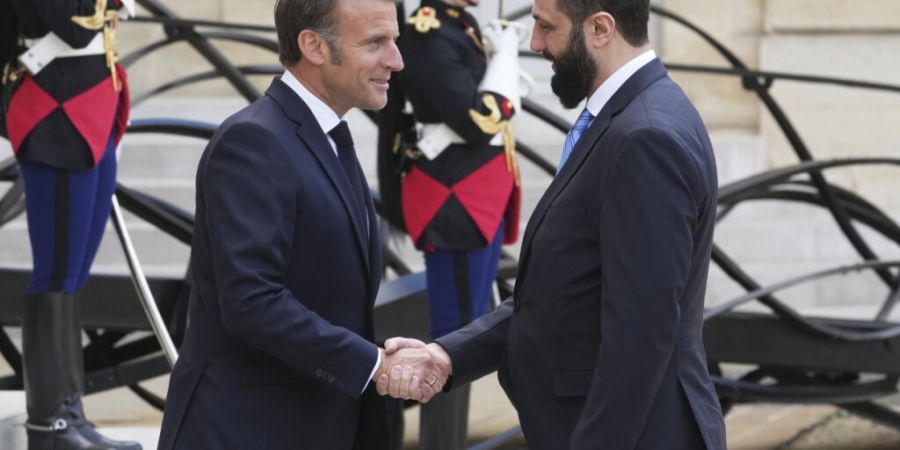 ARCHIV - Der französische Präsident Emmanuel Macron (l) begrüßt den syrischen Interimspräsidenten Ahmed al-Scharaa vor ihren Gesprächen im Elysee-Palast. Foto: Michel Euler/AP/dpa