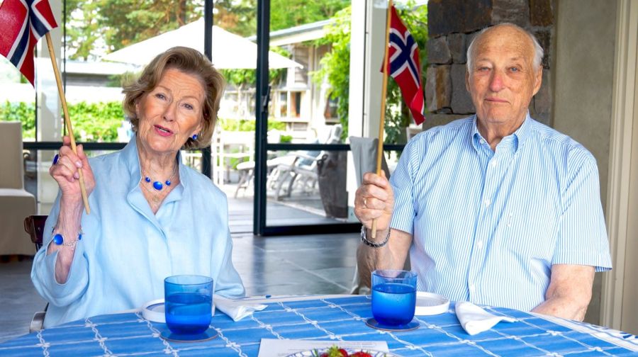Königin Sonja und König Harald schwenken die Fahnen für ihr Land.
