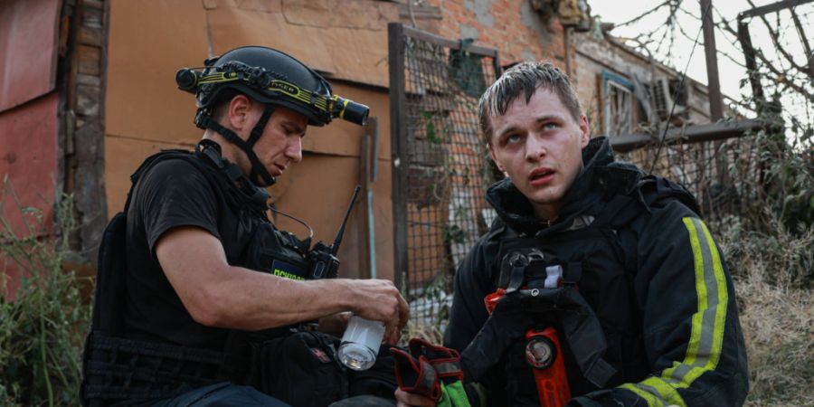 dpatopbilder - Rettungskräfte ruhen sich an einem Ort aus, an dem ein russischer Angriff auf ein Wohngebiet stattgefunden hat. Foto: Kateryna Klochko/AP/dpa