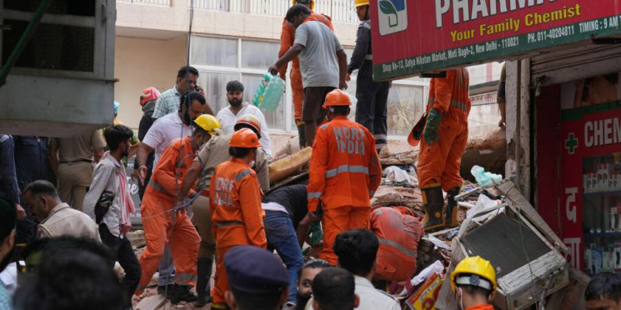 Rettungskräfte suchen in Neu-Delhi unter den Trümmern eines eingestürzten Gebäudes nach Überlebenden. Foto: Rajesh Kumar Singh/AP/dpa