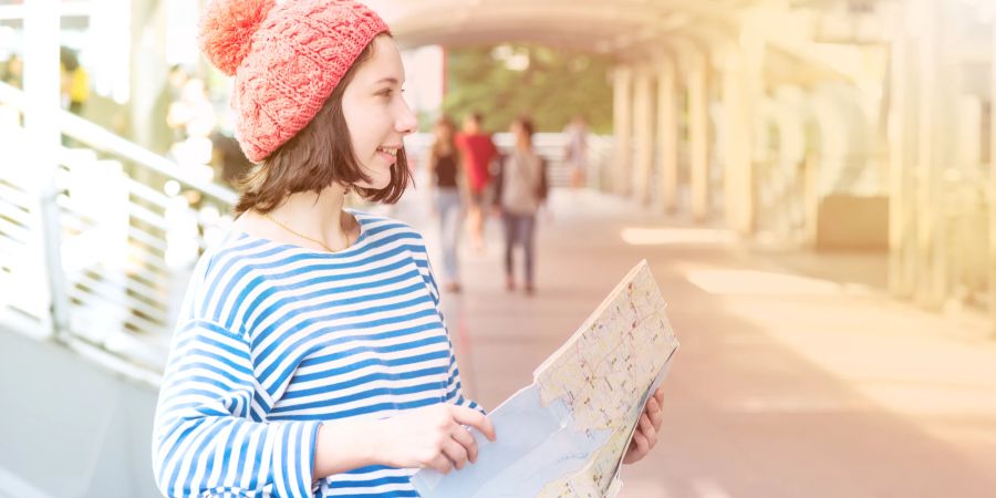 Junge Frau mit Stadtplan auf Reisen.