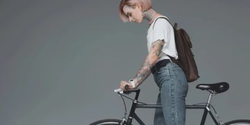 Frau Fahrrad grauer Hintergrund