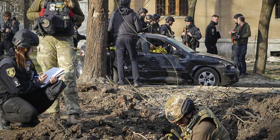 dpatopbilder - Militärexperten untersuchen den Ort eines russischen Bombenangriffs, bei dem mehrere Menschen getötet wurden. Foto: Andrii Marienko/AP/dpa