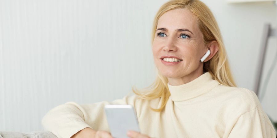 Frau mit AirPods und Smartphone