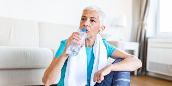 Frau trinkt Wasser nach dem Sport