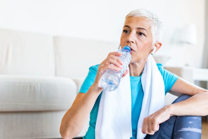 Frau trinkt Wasser nach dem Sport