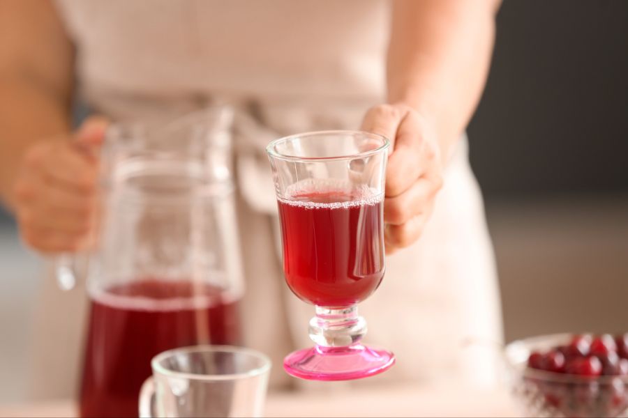 Person hält Glas mit Kirschsaft