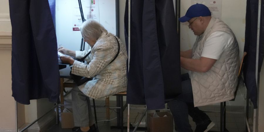 dpatopbilder - Wähler füllen bei den Parlamentswahlen in einem Wahllokal ihre Stimmzettel aus. Foto: Roman Koksarov/AP/dpa/Archivbild