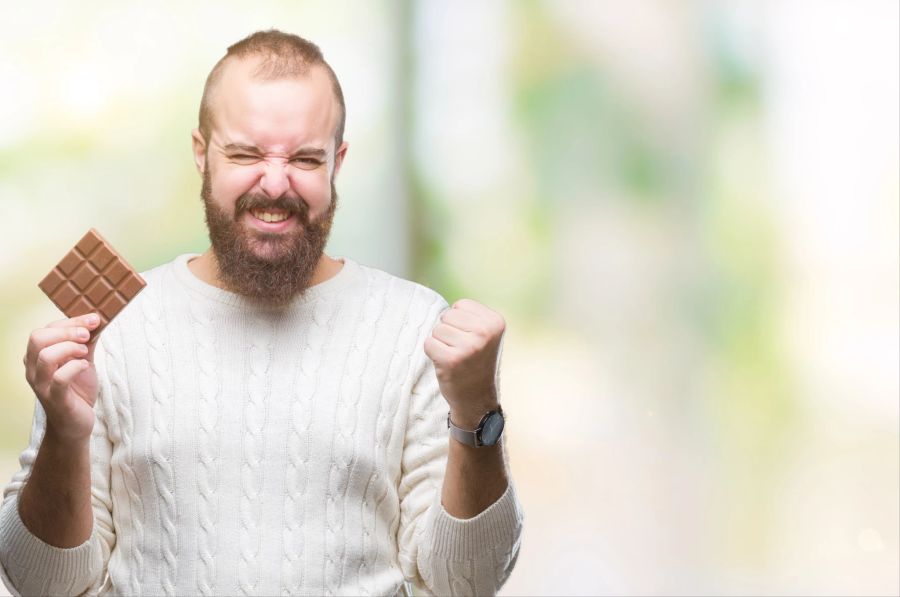 mann mit schokolade in der hand, glücklich