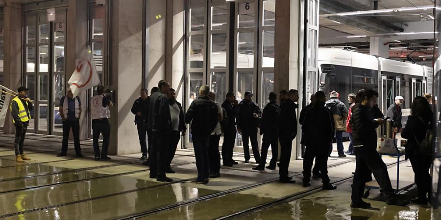 Streikposten verhindern am frühen Mittwochmorgen in Genf die Ausfahrt von Trams und Bussen aus den Depots.