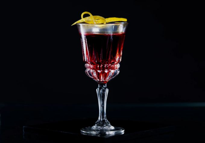 Gerührt und nicht geschüttelt: Gin und roter Wermut werden für den Dubonnet Cocktail auf Eis gerührt und nicht geshakt. Glas rot Wermut Ging Zitrone