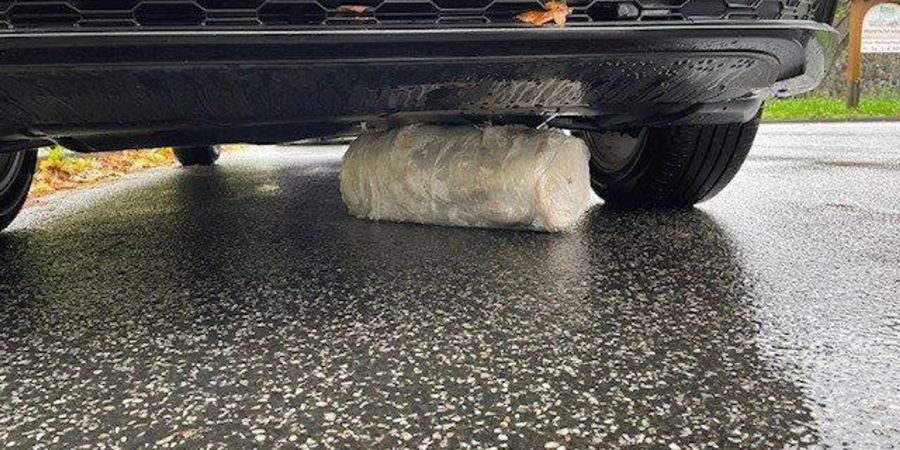 Ein Dönerspiess liegt verkeilt unter einem Auto (beste verfügbare Qualität).