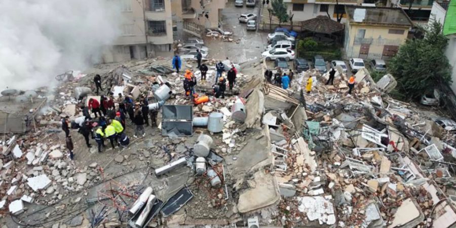 Notfallteams suchen nach Menschen in einem zerstörten Gebäude. Foto: DIA Images/AP/dpa