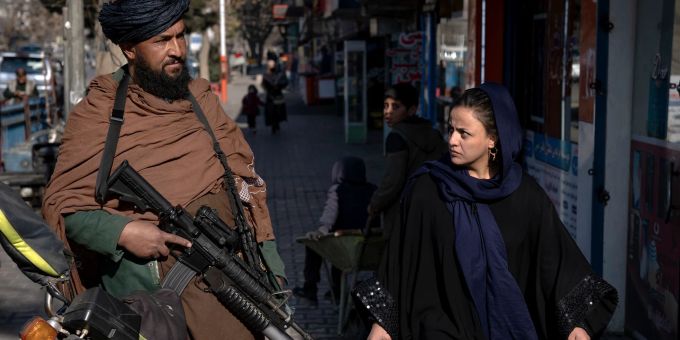 Mit kritischem Blick geht eine Frau in Kabul an einem Taliban-Kämpfer vorbei. Die Islamisten machen bisher keine Anstalten, älteren Mädchen und Frauen den Zugang zu Bildungseinrichtungen zu gewähren. afghanistan