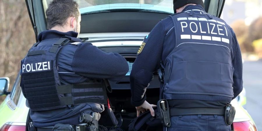 Polizisten an einem Auto