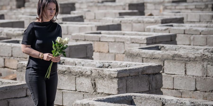 Annalena Baerbock legt Blumen am Friedhof von Kocho im Irak nieder.
