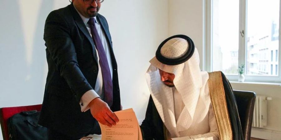 Prinz Mulham al-Schibli vom Fawara-Stamm aus Syrien beim Unterzeichnen des «Verhaltenskodex für ein syrisches Zusammenleben», der deutsch-syrische Verfassungsrechtler Naseef Naeem assistiert. Foto: -/Council of the Syrian Charter/dpa