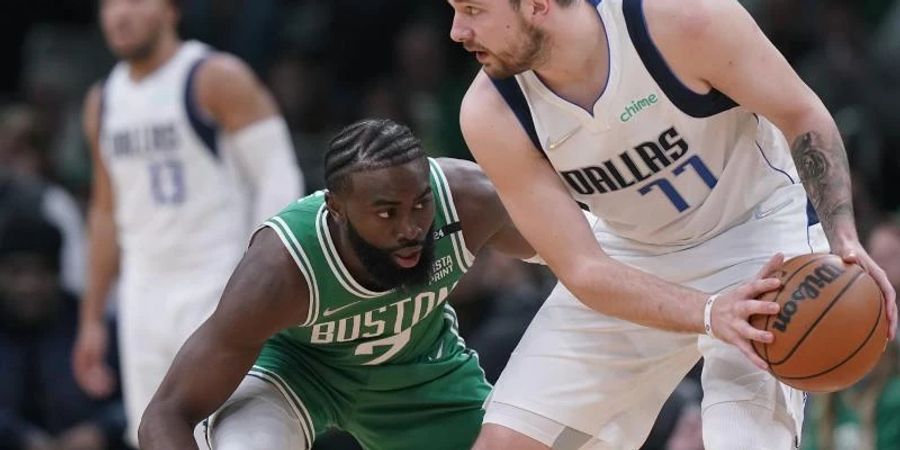 Luka Doncic (r) von den Dallas Mavericks in Aktion mit Jaylen Brown von den Boston Celtics. Foto: Steven Senne/AP/dpa