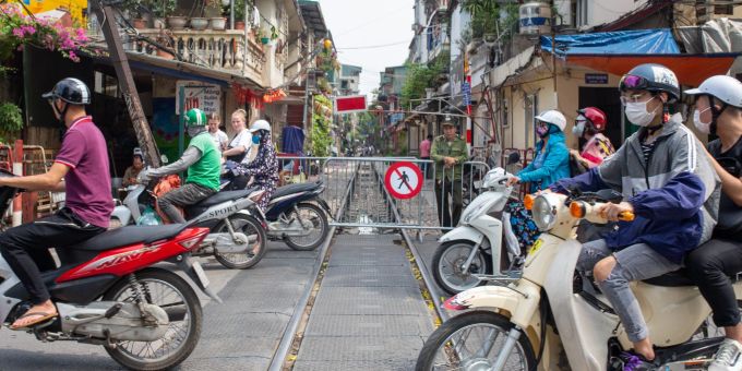 Motorradfahrer überqueren die Train Street in Hanoi, die für Fussgänger gesperrt ist. train street