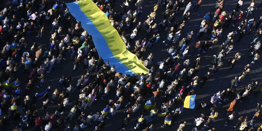 Menschen schauen auf dem Altstädter Ring in Prag die Übertragung des Streaming-Benefizkonzerts «Save Ukraine - #StopWar».