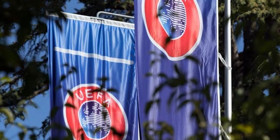 Flaggen mit dem Logo der Europäischen Fussball-Union wehen im Garten des Hauptquartiers der UEFA am Genfer See. Foto: Soeren Stache/dpa