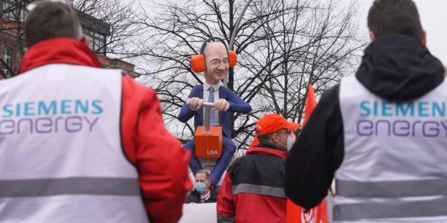 Rund 150 Siemens-Beschäftigte protestieren vor einer lebensgrossen Plastik des Vorstandsvorsitzenden Roland Busch gegen die Abspaltung des Bereichs "Elektrische Grossantriebe". Foto: Joerg Carstensen/dpa