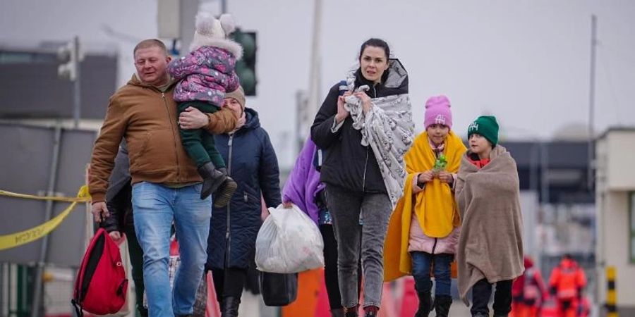 Eine Familie passiert die ukrainisch-polnische Grenze in Medyka. Foto: Kay Nietfeld/dpa