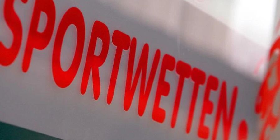 Werbung für Sportwetten klebt an der Schaufensterscheibe eines Wettbüros. Foto: picture alliance / dpa