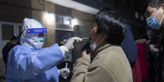 Eine Frau erhält einen Rachenabstrich für einen Coronavirus-Test im Rahmen einer Massenuntersuchung auf das Coronavirus in einer Wohngemeinschaft. Foto: Uncredited/AP/dpa Eine Frau erhält einen Rachenabstrich für einen Coronavirus-Test im Rahmen einer Massenuntersuchung auf das Coronavirus in einer Wohngemeinschaft. Foto: Uncredited/AP/dpa