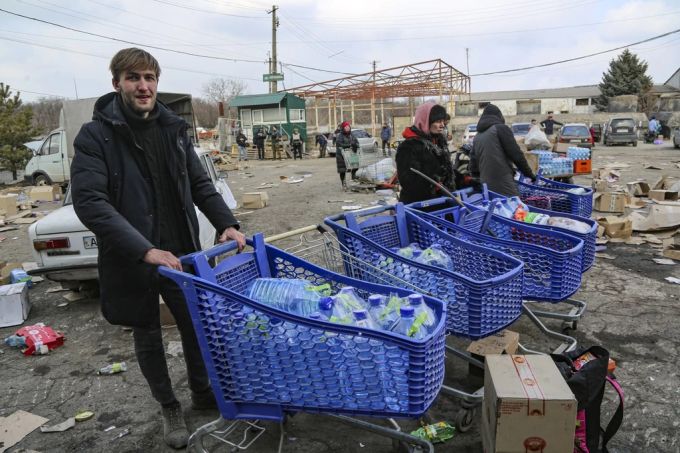 Ukraine Krieg: Bewohner bringen Wasser aus einem von Separatisten kontrollierten Lagerhaus in die Aussenquartiere von Mariupol. Ukraine krieg
