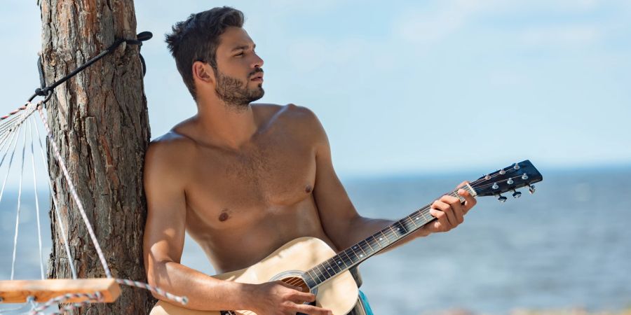 mann mit gitarre am strand