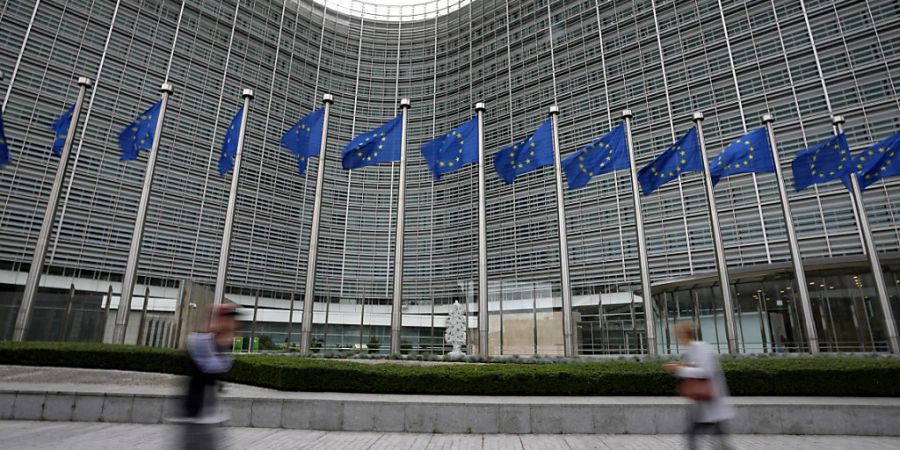 ARCHIV - EU-Fahnen flattern im Wind, während Fussgänger am EU-Hauptsitz vorbeigehen. Die EU will Journalisten und Medienunternehmen besser vor politischer Einflussnahme schützen. Foto: Virginia Mayo/AP/dpa